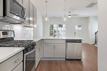 A modern kitchen with stainless steel appliances, subway tile backsplash, and pendant lighting at Turnberry Park Luxury Rental Homes in Gardendale, AL.